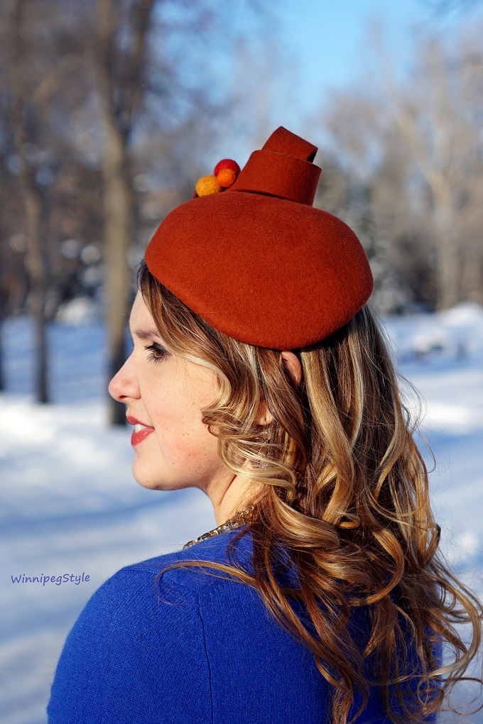 Winnipeg Style, fashion consultant, personal shopper, Coque Millinery by Ericah Rebecca orange wool pom pom winter hat, Chicwish cloud sky print midi skirt, Mary Frances beaded bird clutch purse, Leanimale sloth pin brooch, Lord & Taylor cobalt blue cashmere sweater, orange and blue color combination